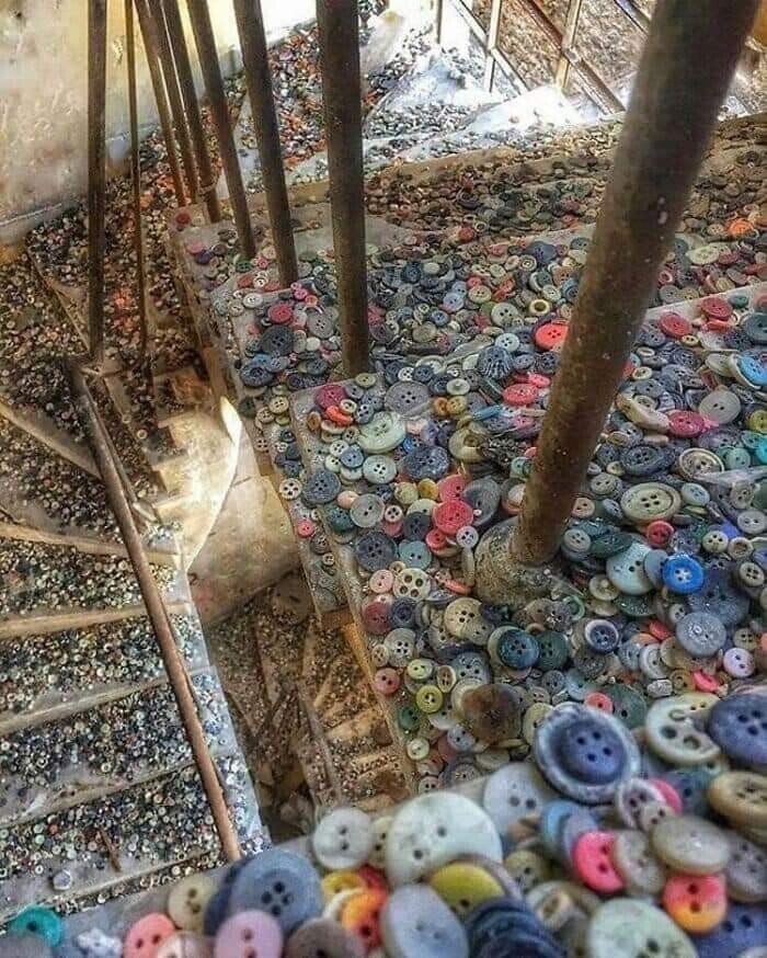 Thousands of colourful buttons of many many varieties cover the stairs in an abandoned button factory.